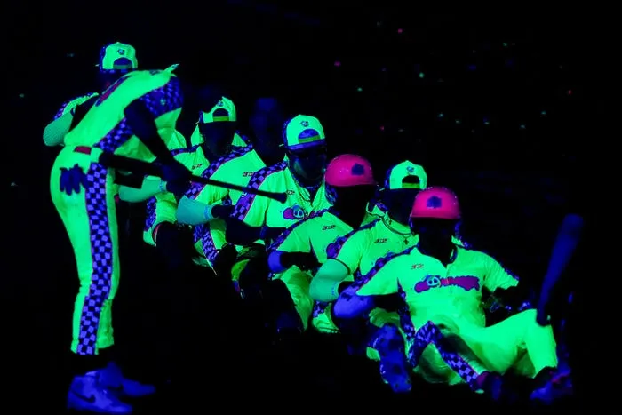 The Cosmic Chili Peppers lined up under blacklights in glowing neon uniforms