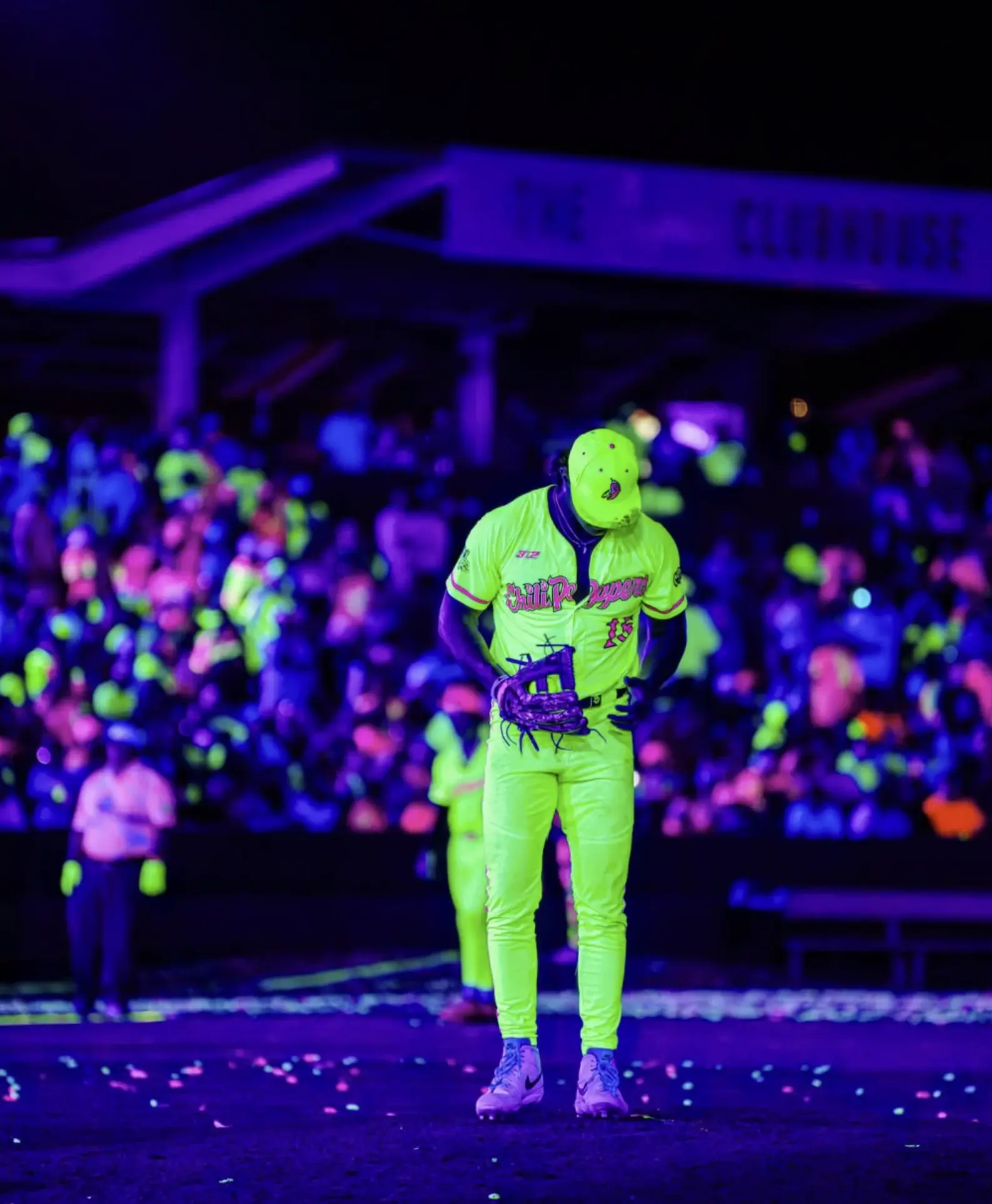 Sam Hanson on the mound under blacklights in his neon Cosmic Chili Peppers uniform