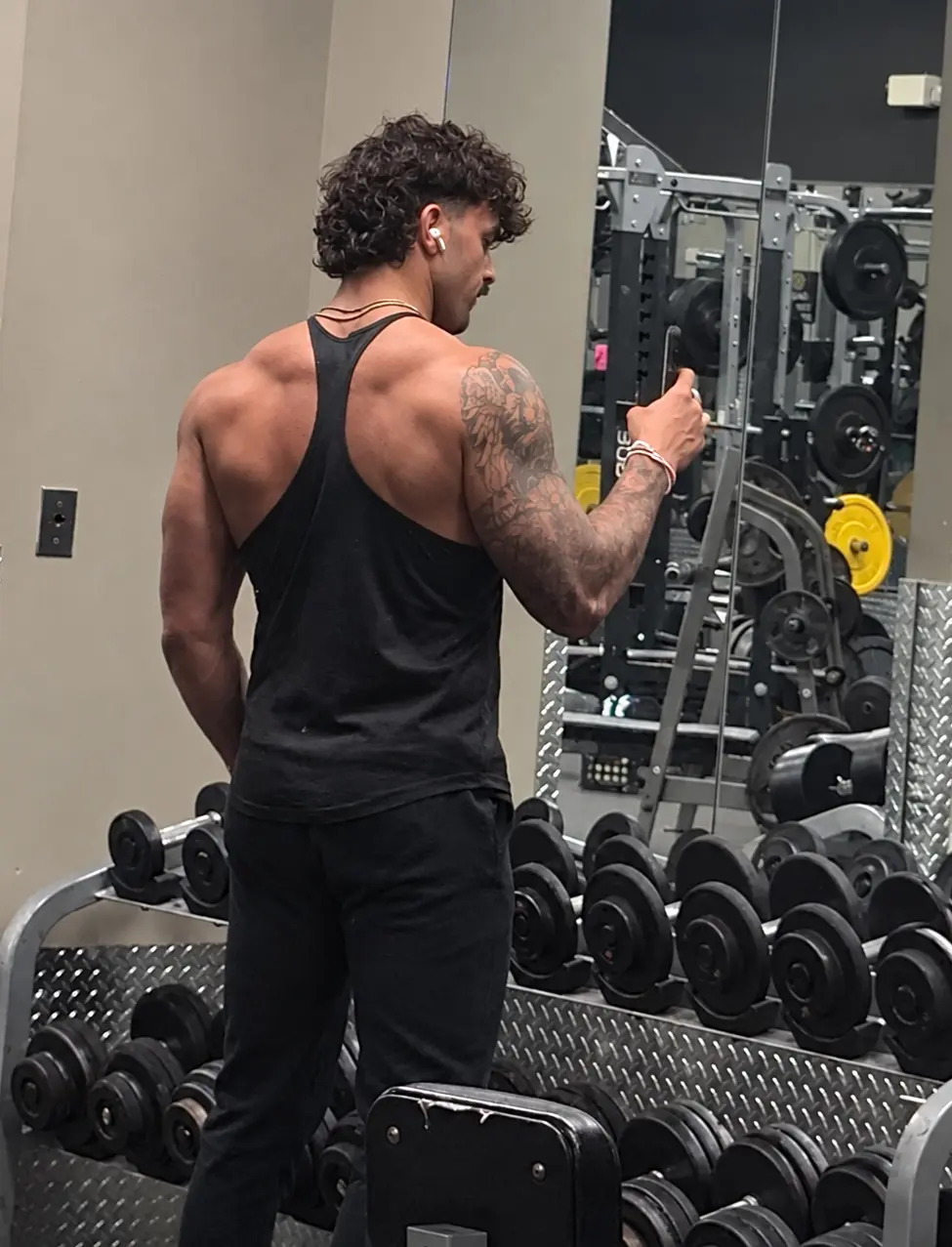 Sam Hanson at the dumbbell rack in the gym