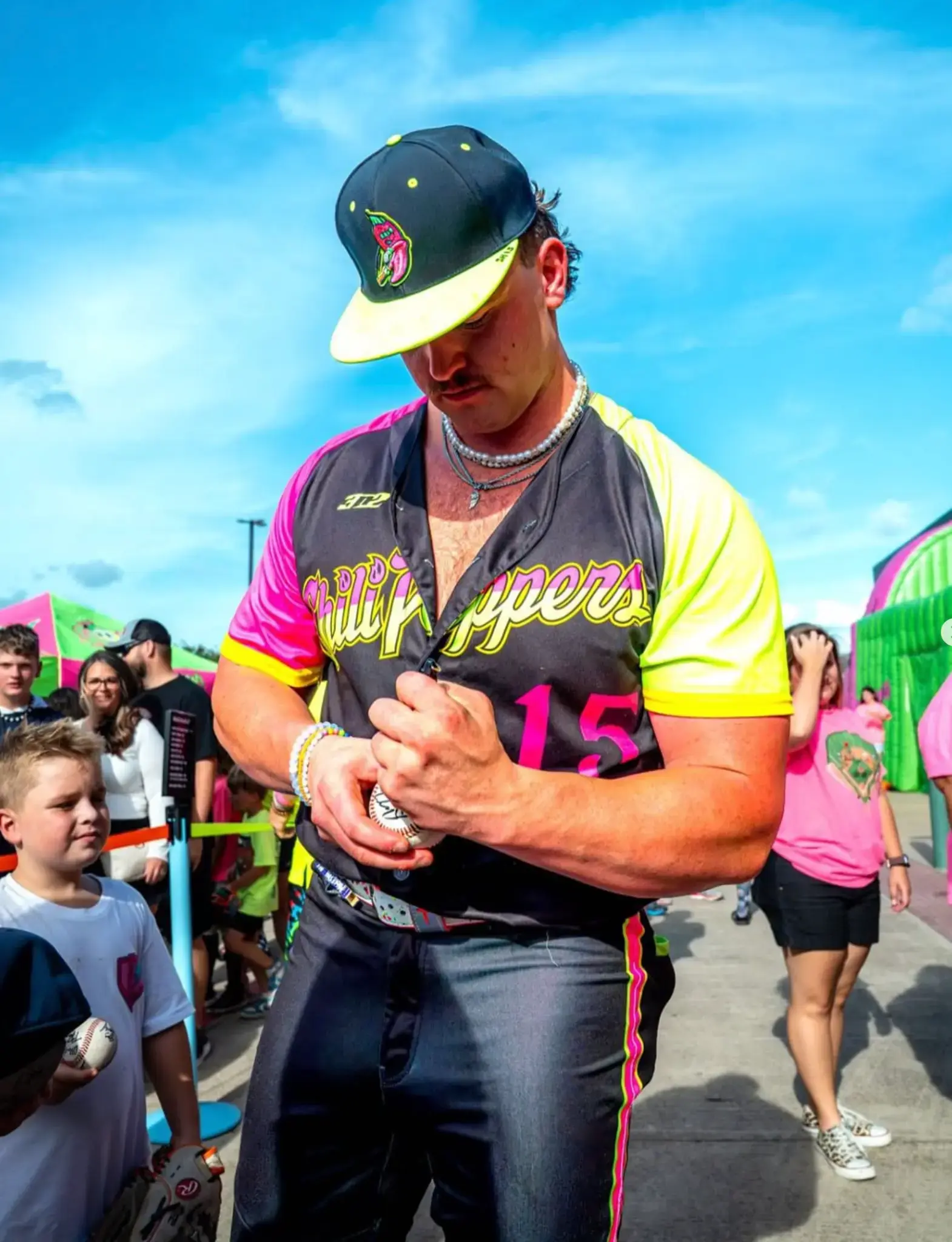 Sam Hanson signing a baseball for young fans before a Cosmic Baseball game